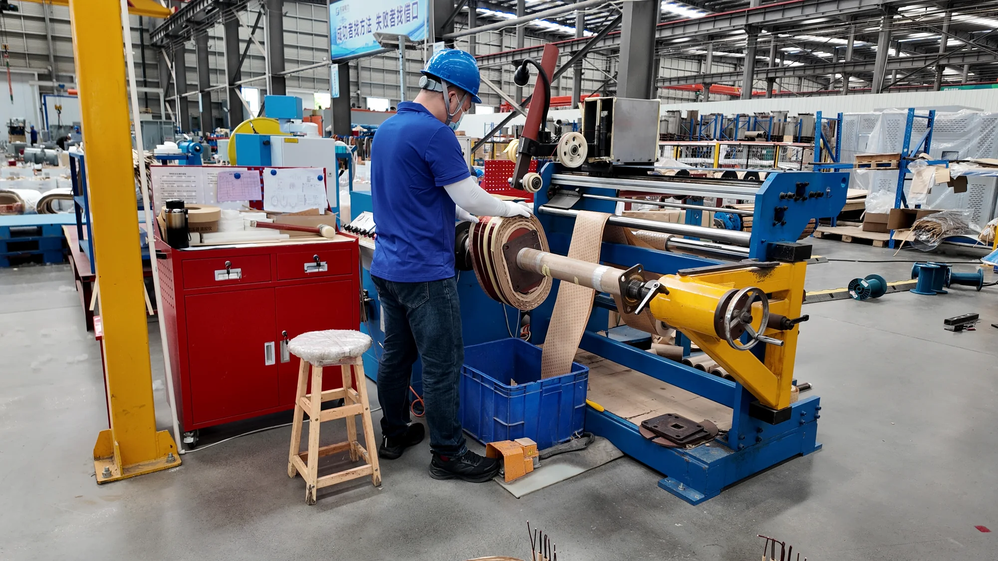 Operator working on a transformer winding machine.